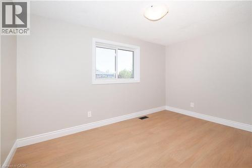 Bright interior space featuring light-toned walls, wood-finish flooring, and white baseboards - 27 Scenic Wood Crescent, Kitchener, ON - Indoor Photo Showing Other Room