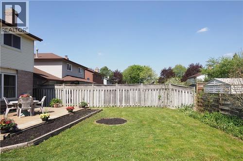 Expansive green lawn with a perimeter wood fence, featuring a raised wood deck - 27 Scenic Wood Crescent, Kitchener, ON - Outdoor