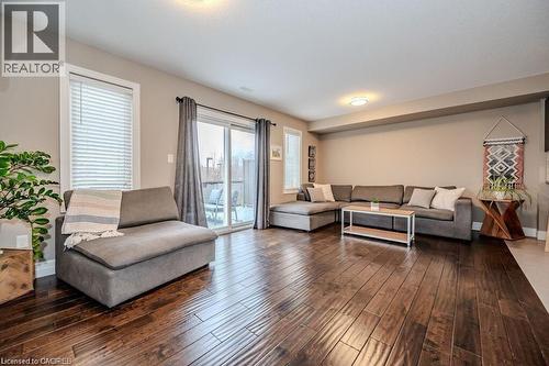 Spacious living area featuring rich wood-finish flooring, recessed lighting, and ample natural light from multiple windows - 275 Old Huron Road Unit# 21, Kitchener, ON - Indoor Photo Showing Living Room