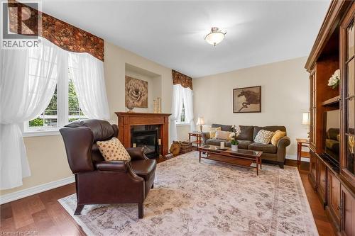 Spacious family room featuring wood-finish flooring, a gas fireplace and ample natural light from multiple windows - 16 Westridge Drive, Hamilton, ON - Indoor Photo Showing Living Room With Fireplace