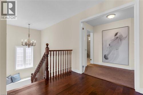 Upper landing featuring wood-finish flooring, red oak staircase with stained railing, pindles & posts and a window seat with storage - 16 Westridge Drive, Hamilton, ON - Indoor Photo Showing Other Room