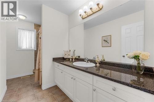 Bathroom featuring a white vanity with extensive storage, a dark granite countertop, and an integrated white sink - 16 Westridge Drive, Hamilton, ON - Indoor Photo Showing Bathroom