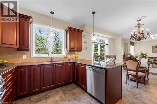 Kitchen featuring rich wood cabinetry with crown molding, finished skirting, granite countertops, tile flooring, a stainless steel Miiele dishwasher (2025) - 16 Westridge Drive, Hamilton, ON - Indoor Photo Showing Kitchen With Double Sink