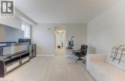 Spacious room featuring light-toned flooring, white walls, and a window with blinds - 