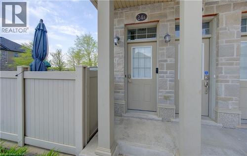 Stone facade entryway featuring an overhead house number, two light fixtures, and a privacy fence - 388 Old Huron Road Unit# 24A, Kitchener, ON - Outdoor