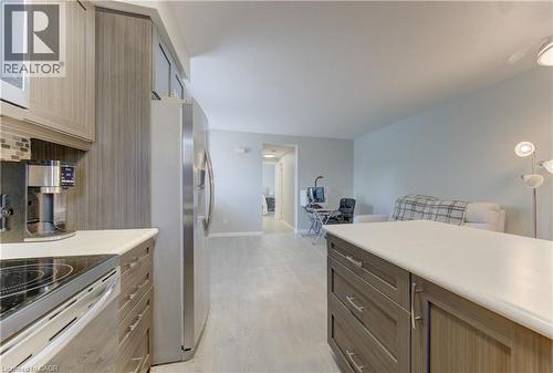 Kitchen featuring wood-finish cabinetry, stainless steel appliances, a light-colored countertop, and a tiled backsplash - 388 Old Huron Road Unit# 24A, Kitchener, ON - Indoor Photo Showing Kitchen