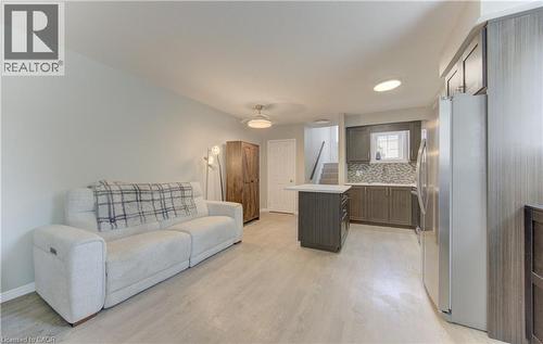 Open-concept living area featuring light wood-finish flooring, recessed lighting, and a neutral color palette - 388 Old Huron Road Unit# 24A, Kitchener, ON - Indoor