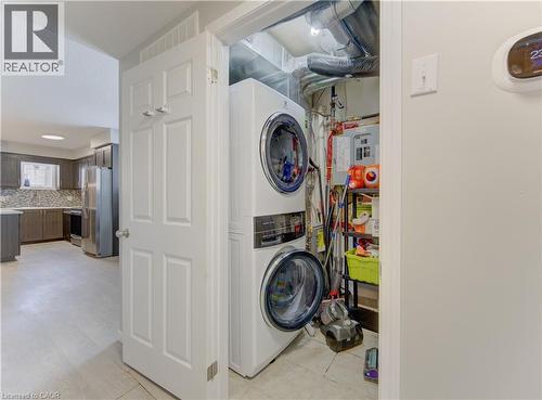 Dedicated laundry closet featuring a stacked washer and dryer unit - 388 Old Huron Road Unit# 24A, Kitchener, ON - Indoor Photo Showing Laundry Room
