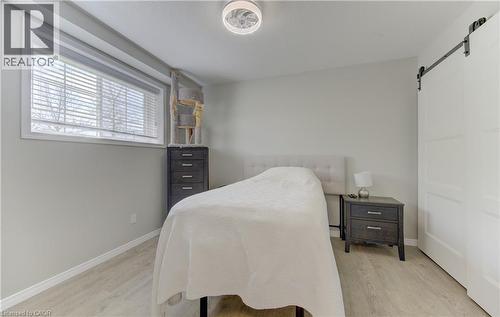 Spacious room featuring light-toned walls, wood-finish flooring, and a large window with blinds - 388 Old Huron Road Unit# 24A, Kitchener, ON - Indoor Photo Showing Bedroom