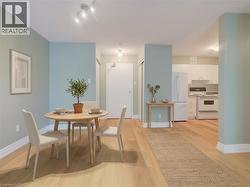 Open-concept dining area featuring wood-finish flooring, light blue wall paint, white baseboards, and track lighting - 