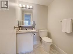 Bathroom featuring a single vanity with an integrated sink, a frameless mirror, and a five-bulb vanity light fixture - 