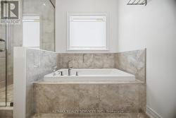 Ensuite soaker tub with window above & ceramics - 