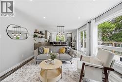 Open-concept living space featuring wood-finish flooring, recessed lighting, and a large picture window - 