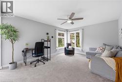 Spacious room with light gray walls and neutral carpet flooring - 