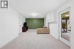 Light-colored carpeting and white walls create a bright living space - 