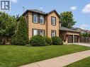 Two-story brick exterior with dark shutters, dual garage doors, and a paved driveway - 3311 Springvale Court, Burlington, ON  - Outdoor 