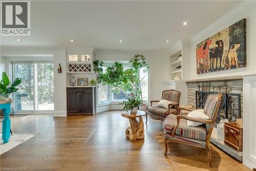 Living area with built in features, a fireplace, light wood-style flooring, ornamental molding, and recessed lighting - 3311 Springvale Court, Burlington, ON - Indoor Photo Showing Living Room