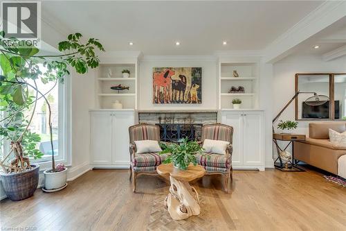 Sitting room with built in features, light wood finished floors, crown molding, a fireplace, and recessed lighting - 3311 Springvale Court, Burlington, ON - Indoor