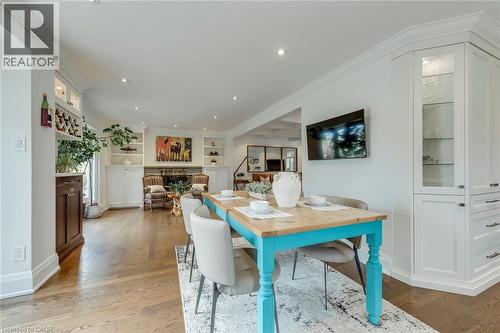 Dining space featuring light wood-style flooring, built in features, recessed lighting, ornamental molding, and a fireplace - 3311 Springvale Court, Burlington, ON - Indoor Photo Showing Dining Room