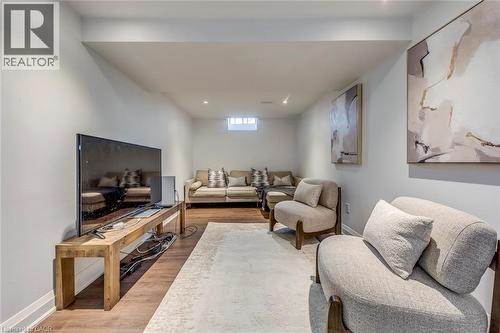 This living area features light-colored walls, recessed lighting, and wood-look flooring - 3311 Springvale Court, Burlington, ON - Indoor