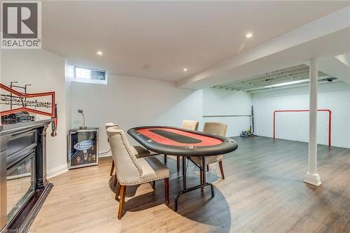 The property features a spacious entertainment area with light-colored flooring, recessed lighting, and a window - 3311 Springvale Court, Burlington, ON - Indoor