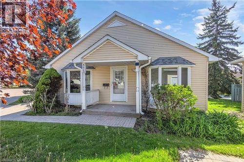 Cream-colored siding exterior featuring a covered porch entryway and an architectural bay window - 375 Silverbirch Boulevard, Hamilton, ON - Outdoor With Facade