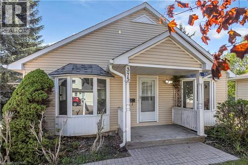 Single-story residence featuring light-colored siding, a covered front porch, and a bay window with a shingled roof - 375 Silverbirch Boulevard, Hamilton, ON - Outdoor