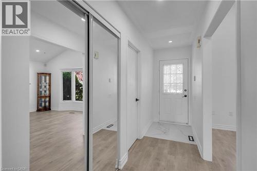Entryway featuring wood-finish flooring, white walls, and a white front door with multiple glass panes - 375 Silverbirch Boulevard, Hamilton, ON - Indoor Photo Showing Other Room
