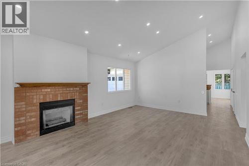 Living area featuring a brick fireplace with a wood mantle, recessed lighting, and wood-finish flooring - 375 Silverbirch Boulevard, Hamilton, ON - Indoor With Fireplace