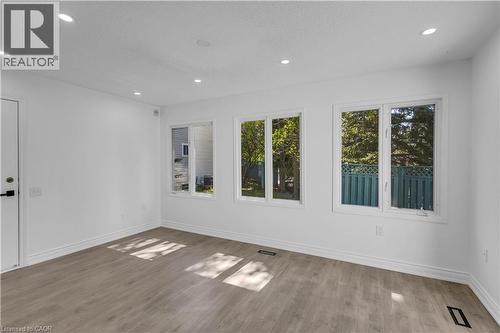 Bright interior space featuring a light wood-finish flooring, recessed ceiling lighting, clean white walls, and multiple windows providing ample ambient illumination - 375 Silverbirch Boulevard, Hamilton, ON - Indoor Photo Showing Other Room