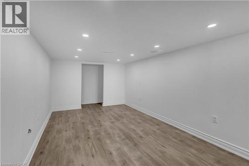 Spacious room featuring wood-finish flooring, recessed lighting, white walls, and white baseboards - 375 Silverbirch Boulevard, Hamilton, ON - Indoor Photo Showing Other Room