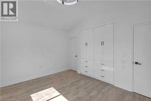 Bright interior space featuring a vaulted ceiling and wood-finish flooring - 375 Silverbirch Boulevard, Hamilton, ON - Indoor Photo Showing Other Room