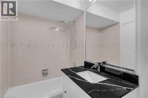 Bathroom vanity with a black countertop and integrated rectangular sink - 375 Silverbirch Boulevard, Hamilton, ON - Indoor Photo Showing Bathroom