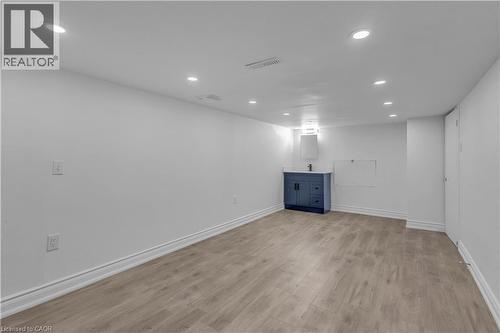 Spacious room with wood-finish flooring, recessed lighting, and white baseboards - 375 Silverbirch Boulevard, Hamilton, ON - Indoor