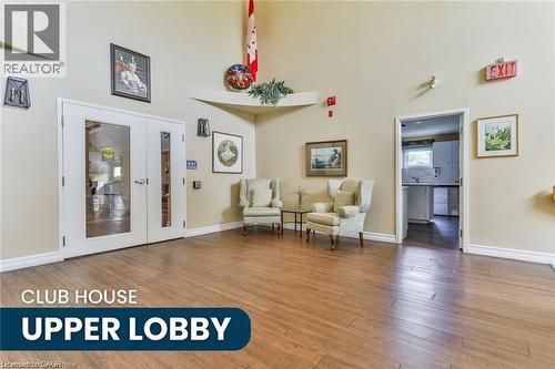 Spacious common area featuring wood-finish flooring, light-toned walls, and double glass-paneled doors - 375 Silverbirch Boulevard, Hamilton, ON - Indoor Photo Showing Other Room