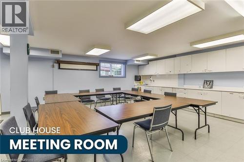 Spacious meeting room featuring a U-shaped table configuration, ample overhead lighting, extensive built-in cabinetry, and a window providing exterior light - 375 Silverbirch Boulevard, Hamilton, ON - Indoor