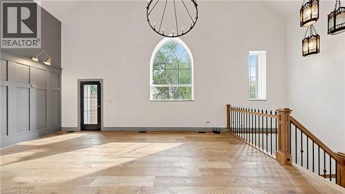 Soaring vaulted ceiling featuring a large arched window and a striking circular chandelier - 41 Talbot Road, Delhi, ON - Indoor Photo Showing Other Room