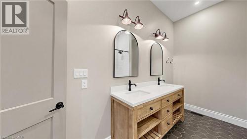 Dual vanity with white countertop, black fixtures, and wood-finish cabinetry - 41 Talbot Road, Delhi, ON - Indoor Photo Showing Bathroom