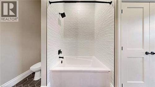 White subway tile shower surround with textured finish, featuring matte black fixtures and a white tub - 41 Talbot Road, Delhi, ON - Indoor Photo Showing Bathroom