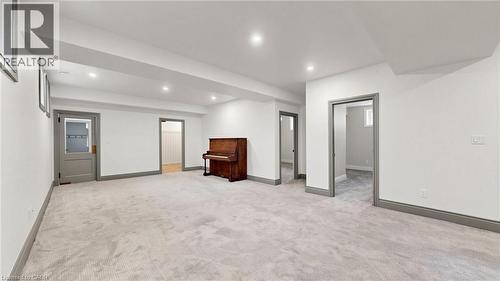 Expansive carpeted room featuring recessed lighting, multiple doorways with grey trim, and white painted walls - 41 Talbot Road, Delhi, ON - Indoor