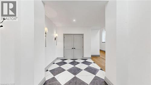 Entryway featuring a black and white checkered floor, two wall sconces, a pair of paneled doors, and a recessed ceiling light - 41 Talbot Road, Delhi, ON - Indoor