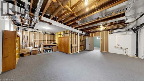 Spacious unfinished basement with exposed wooden joists and ductwork, featuring a carpeted floor, framed partition walls, and painted white walls - 41 Talbot Road, Delhi, ON - Indoor Photo Showing Basement