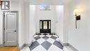 Grand foyer featuring a black and white checkerboard tile floor, soaring ceilings, a transom window, and a dark paneled front door with glass inserts - 41 Talbot Road, Delhi, ON  - Indoor Photo Showing Other Room 