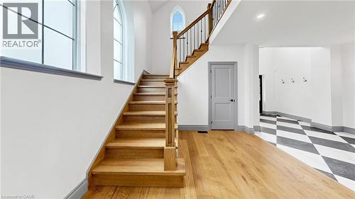 Grand staircase with natural wood treads and wrought iron balusters - 41 Talbot Road, Delhi, ON - Indoor Photo Showing Other Room