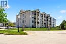Multi-story residential building featuring multiple private balconies, a light gray exterior, and gabled rooflines - 1411 Walker'S Line Unit# 105, Burlington, ON  - Outdoor With Facade 