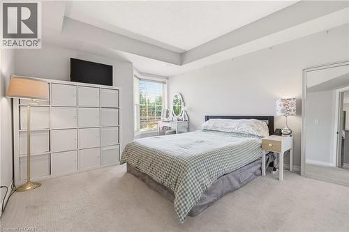 Bedroom featuring a bay window, tray ceiling, wall-to-wall carpeting, and light gray wall paint - 1411 Walker'S Line Unit# 105, Burlington, ON - Indoor Photo Showing Bedroom