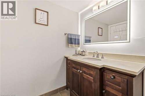 Vanity with a built-in sink, light-toned countertop, and chrome faucet - 1411 Walker'S Line Unit# 105, Burlington, ON - Indoor
