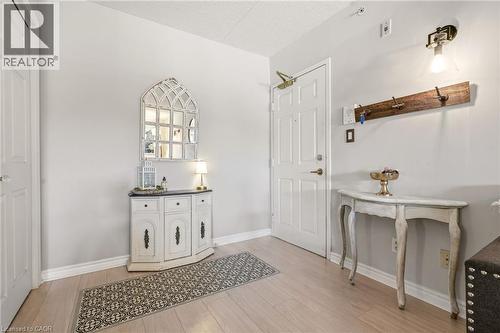 Entryway featuring light wood-finish flooring, white walls, and a paneled entry door - 1411 Walker'S Line Unit# 105, Burlington, ON - Indoor Photo Showing Other Room