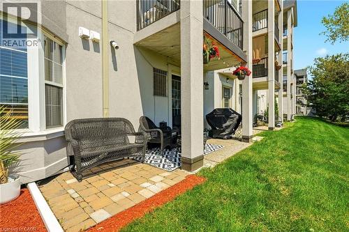 Ground-level patio area featuring paver flooring and direct access to a grassy expanse - 1411 Walker'S Line Unit# 105, Burlington, ON - Outdoor