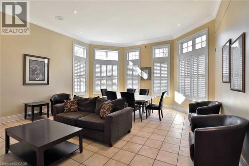Open-concept living area featuring a neutral color palette, recessed lighting, crown molding, and large windows with white louvered shutters - 1411 Walker'S Line Unit# 105, Burlington, ON - Indoor Photo Showing Living Room